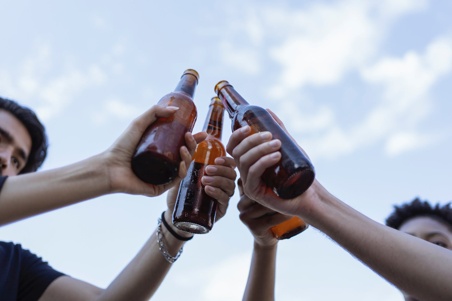 people holding beer bottles